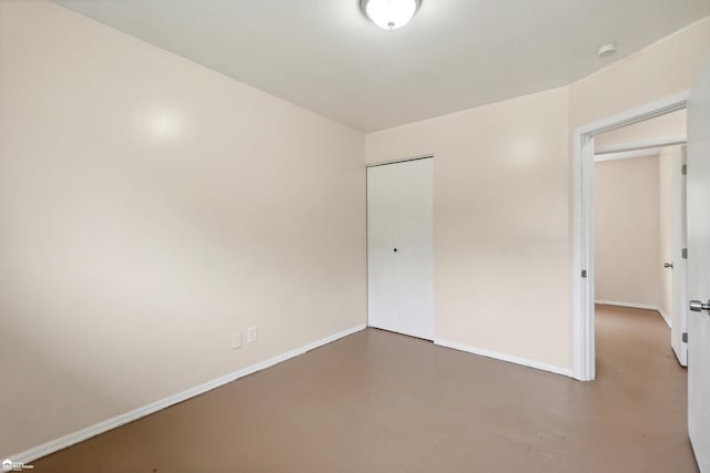 unfurnished bedroom featuring concrete floors and a closet