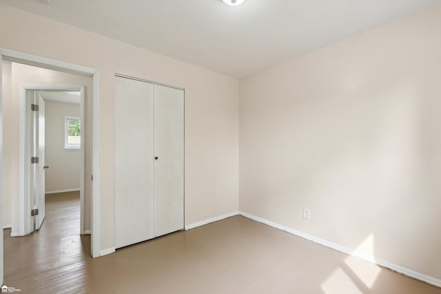 unfurnished bedroom with a closet and hardwood / wood-style floors