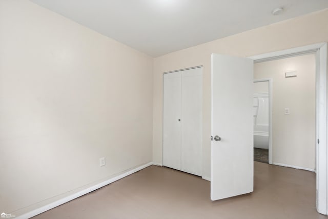 unfurnished bedroom with a closet and concrete flooring