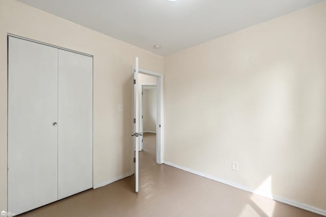 unfurnished bedroom with a closet and concrete floors