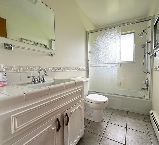 full bathroom with baseboard heating, tile patterned flooring, toilet, shower / bath combination with glass door, and vanity