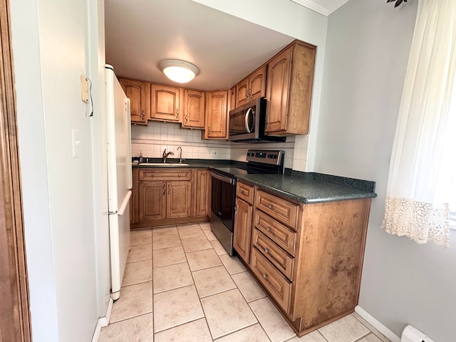 kitchen featuring sink, decorative backsplash, light tile patterned floors, a baseboard radiator, and stainless steel appliances