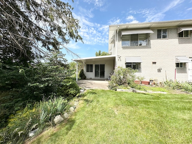 rear view of house with a patio area and a lawn