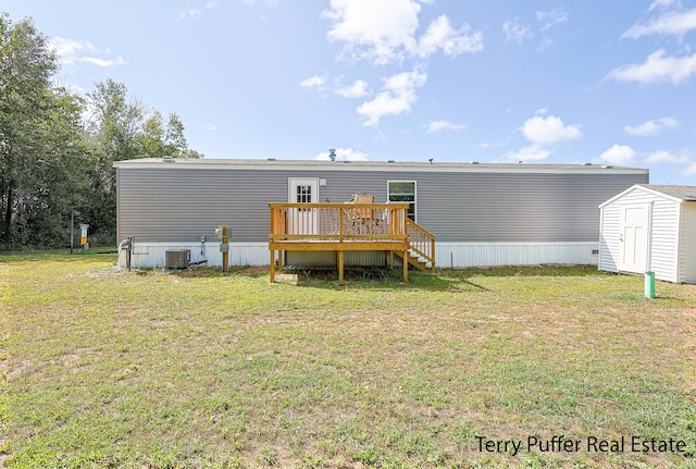 back of house with a yard, a shed, cooling unit, and a wooden deck