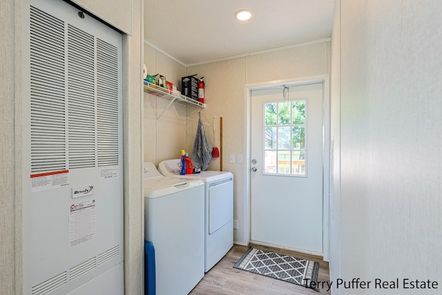 laundry area featuring washer and clothes dryer, light hardwood / wood-style floors, and ornamental molding