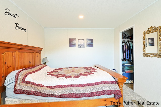 bedroom featuring wood-type flooring, a walk in closet, crown molding, and a closet