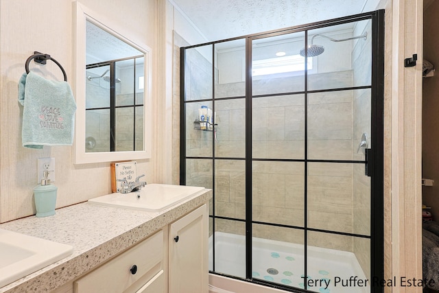 bathroom with a shower with door and vanity