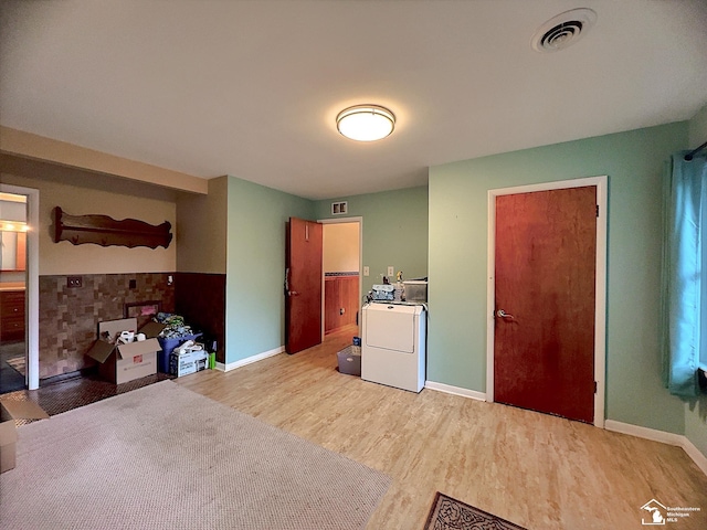 interior space featuring washer / dryer, stove, and light wood-type flooring