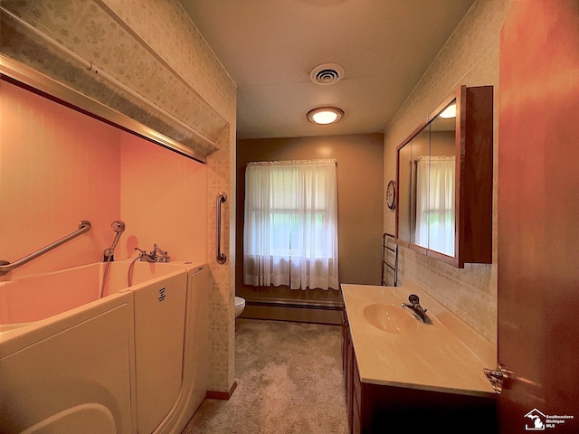 bathroom featuring washing machine and clothes dryer, vanity, and toilet