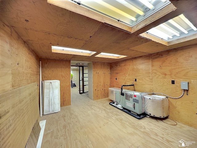 basement with wood walls and light hardwood / wood-style flooring