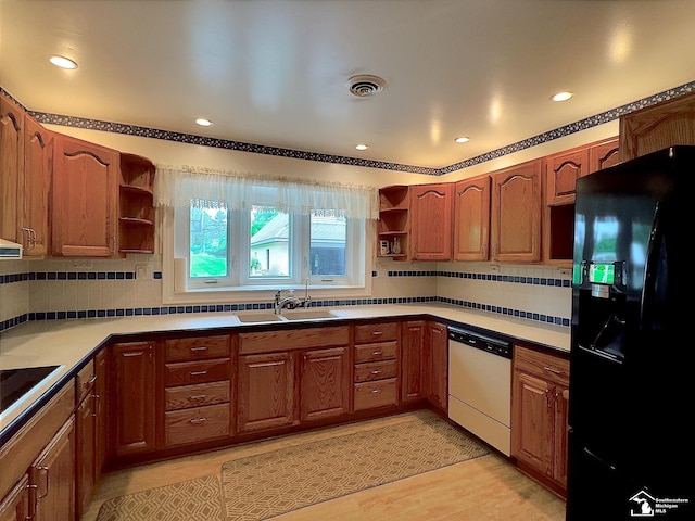 kitchen with black appliances, backsplash, light hardwood / wood-style floors, and sink