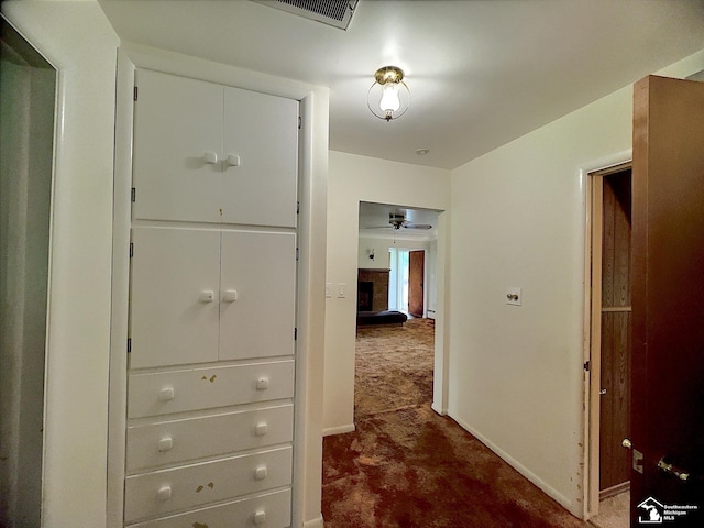 hall featuring dark colored carpet