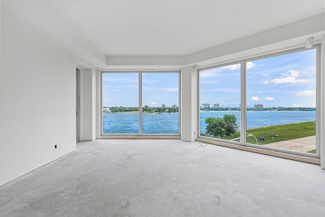 spare room with concrete floors and a water view