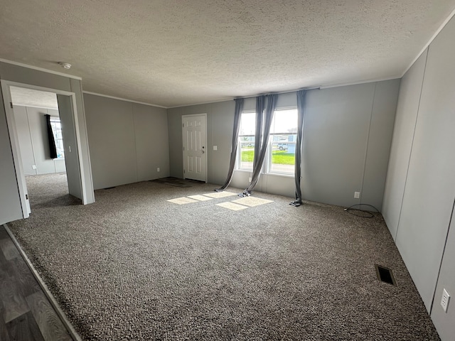 carpeted empty room featuring a textured ceiling and ornamental molding