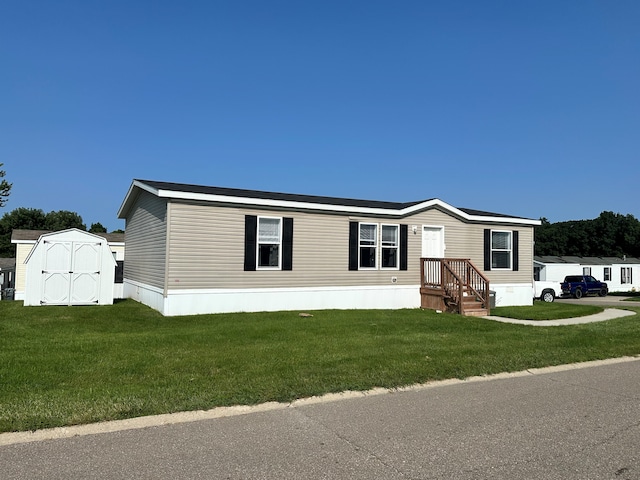 manufactured / mobile home featuring a front yard and a shed