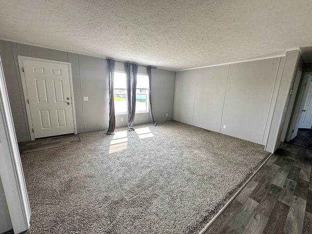 empty room with a textured ceiling and dark wood-type flooring