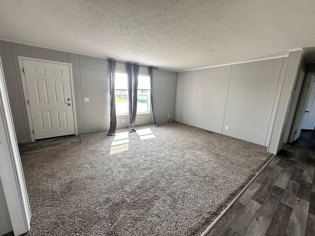 16678 Lakewood Dr, Holly, MI 48442 - entryway featuring dark wood-type flooring, a textured ceiling, and a decorative wall