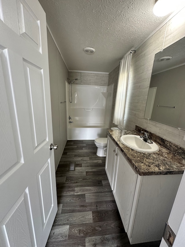 full bathroom with toilet, vanity, a textured ceiling, and hardwood / wood-style flooring