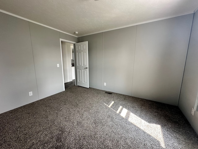 carpeted empty room featuring crown molding and a textured ceiling