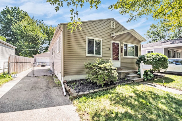 view of front of home featuring a front yard, a garage, and an outdoor structure