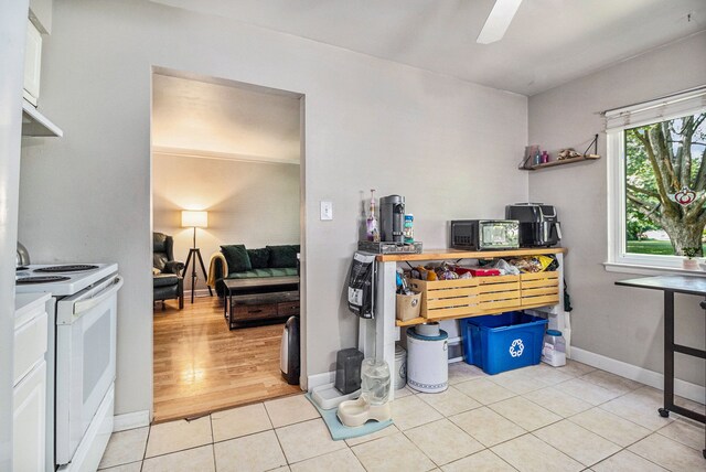 interior space featuring white electric range oven, light hardwood / wood-style flooring, and ceiling fan