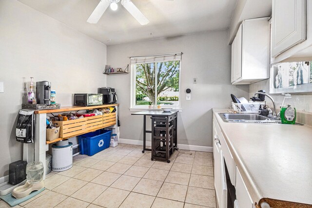 kitchen featuring white cabinets, light tile patterned floors, ceiling fan, and sink