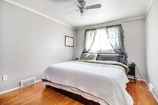 bedroom featuring ceiling fan, hardwood / wood-style floors, and crown molding