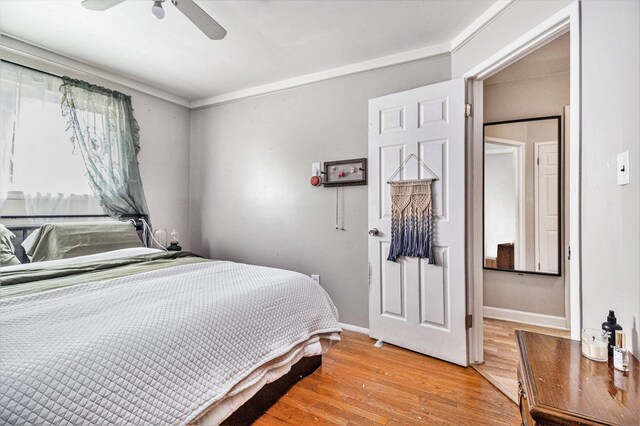 bedroom with light hardwood / wood-style floors, ceiling fan, and ornamental molding