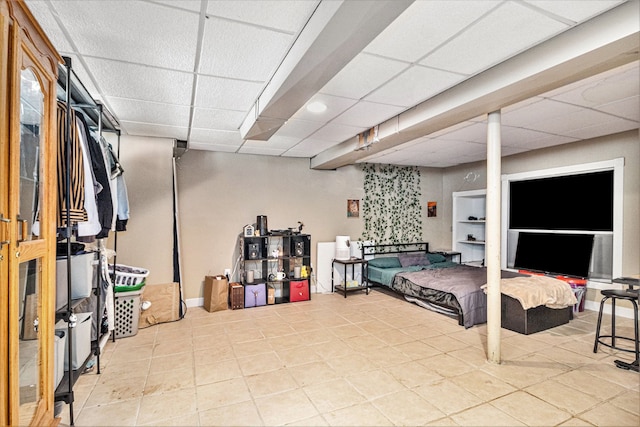 bedroom with a paneled ceiling and light tile patterned flooring