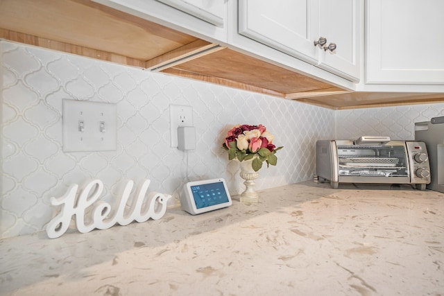 room details with white cabinets and light stone countertops