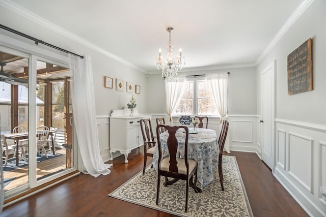 dining room with dark hardwood / wood-style floors, ornamental molding, and a notable chandelier