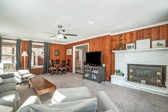 living room with carpet flooring, ornamental molding, and wooden walls