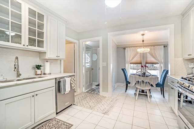 kitchen featuring sink, stainless steel appliances, backsplash, decorative light fixtures, and white cabinets