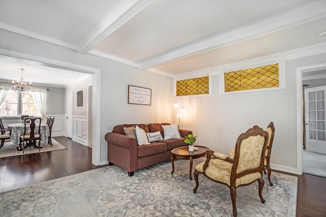 living room with beamed ceiling, a notable chandelier, dark hardwood / wood-style flooring, and ornamental molding