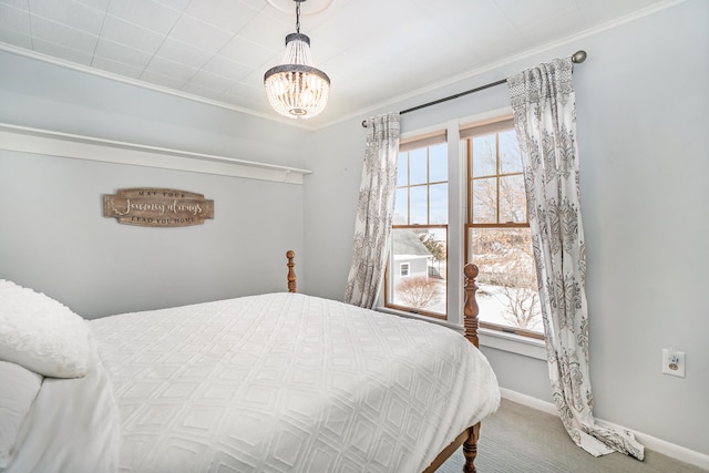 bedroom featuring carpet flooring, ornamental molding, and an inviting chandelier