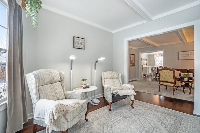 living area with beam ceiling, ornamental molding, and dark wood-type flooring