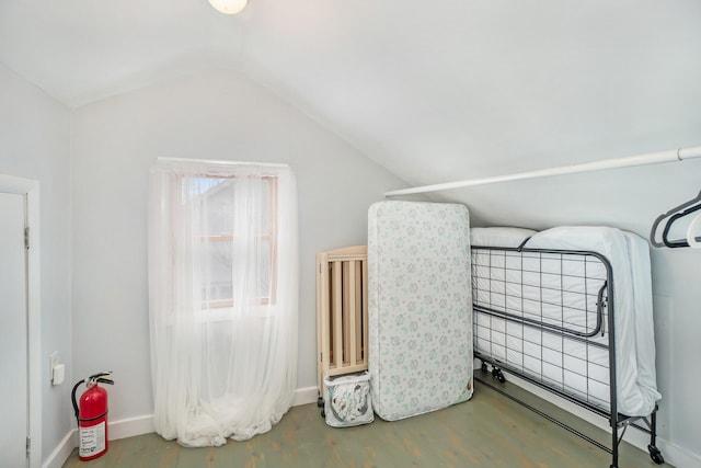 bedroom featuring wood-type flooring and vaulted ceiling