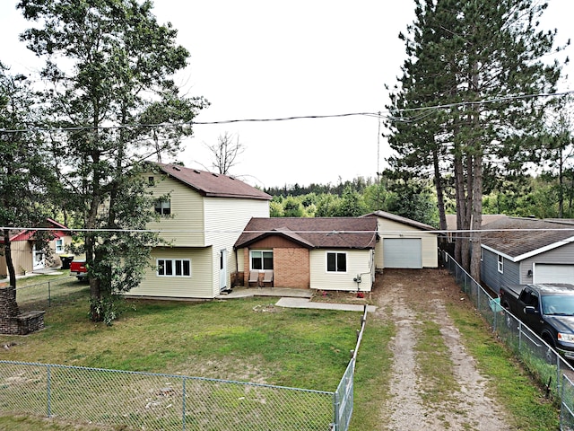 view of front of home with a front yard, an outbuilding, and a garage