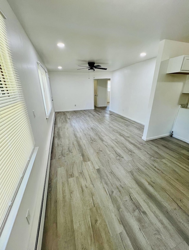 unfurnished living room featuring light wood-type flooring and ceiling fan