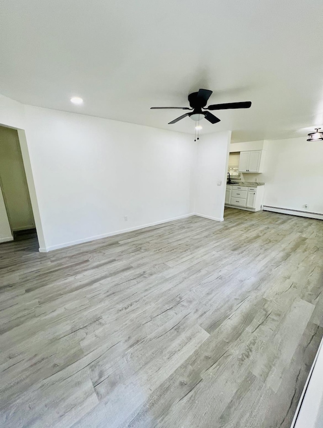 unfurnished living room featuring a baseboard radiator, light hardwood / wood-style floors, and ceiling fan