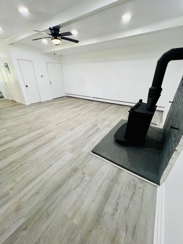 living area featuring light wood-type flooring, ceiling fan, beam ceiling, and a baseboard heating unit