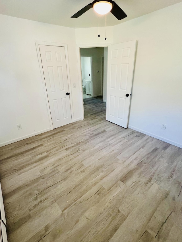 unfurnished bedroom with light wood-type flooring, ceiling fan, and a closet