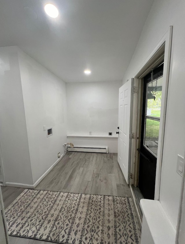 laundry room featuring hookup for a washing machine, hardwood / wood-style floors, and a baseboard radiator