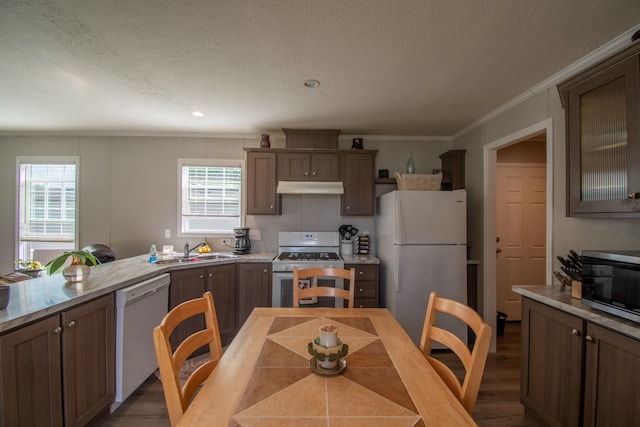 kitchen with white appliances, crown molding, sink, dark hardwood / wood-style floors, and a textured ceiling