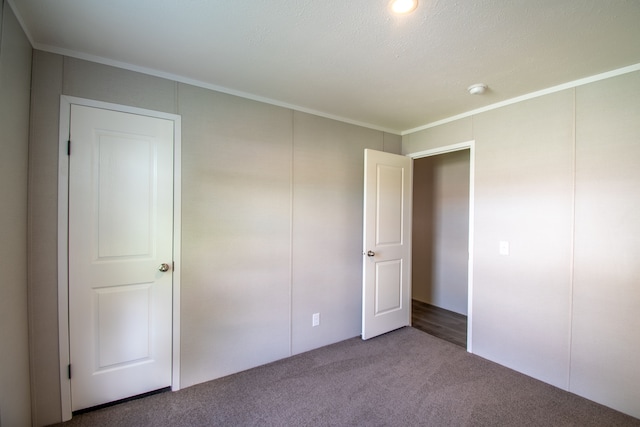 unfurnished bedroom with a textured ceiling, carpet floors, and crown molding