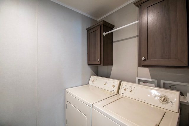 clothes washing area with cabinets, ornamental molding, and washing machine and clothes dryer