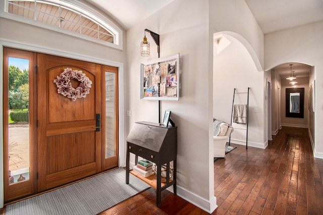 entryway with dark wood-type flooring and high vaulted ceiling