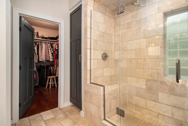 bathroom featuring a shower with door and wood-type flooring