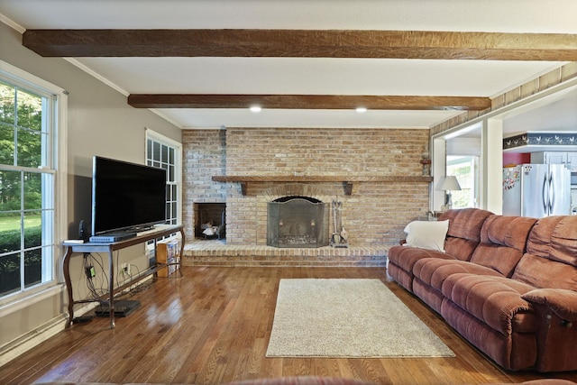 living room featuring a brick fireplace, beamed ceiling, and hardwood / wood-style flooring