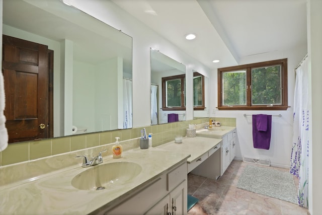 bathroom featuring vanity, a wealth of natural light, and tasteful backsplash